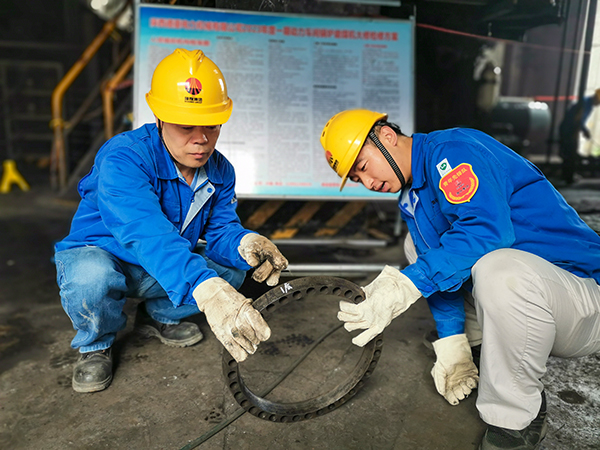 圖三：12日下午14時，在一期磨煤機廠房，陜西省技術能手姬霄給青工張跟潮講解磨煤機搖臂曲拐內環(huán)及動作原理。.jpg